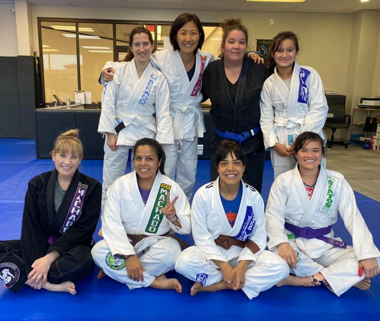 a group of women in karate uniforms are posing for a picture .