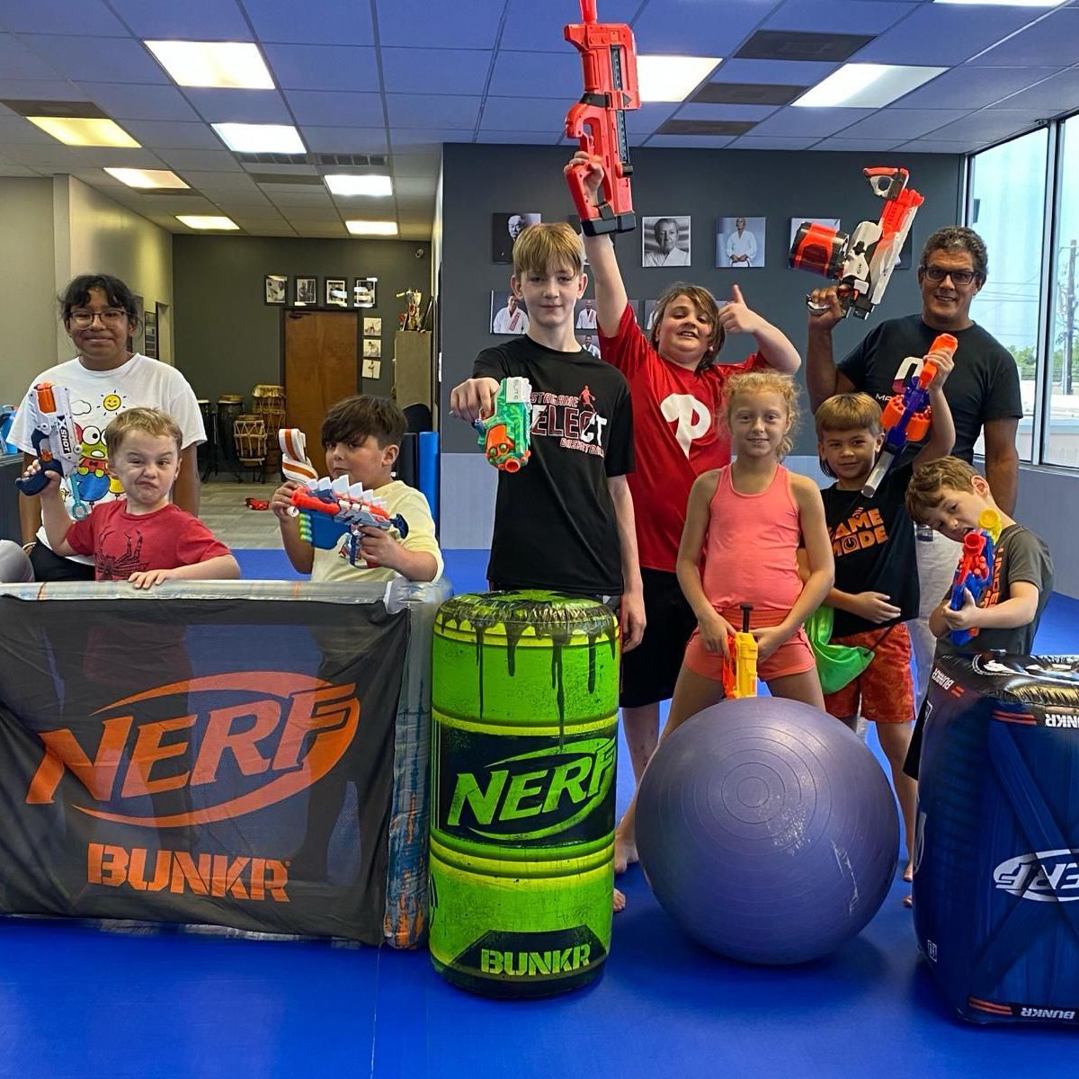 a group of children are posing for a picture with nerf toys