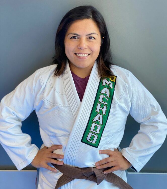 a woman wearing a white karate uniform with the word machado on it