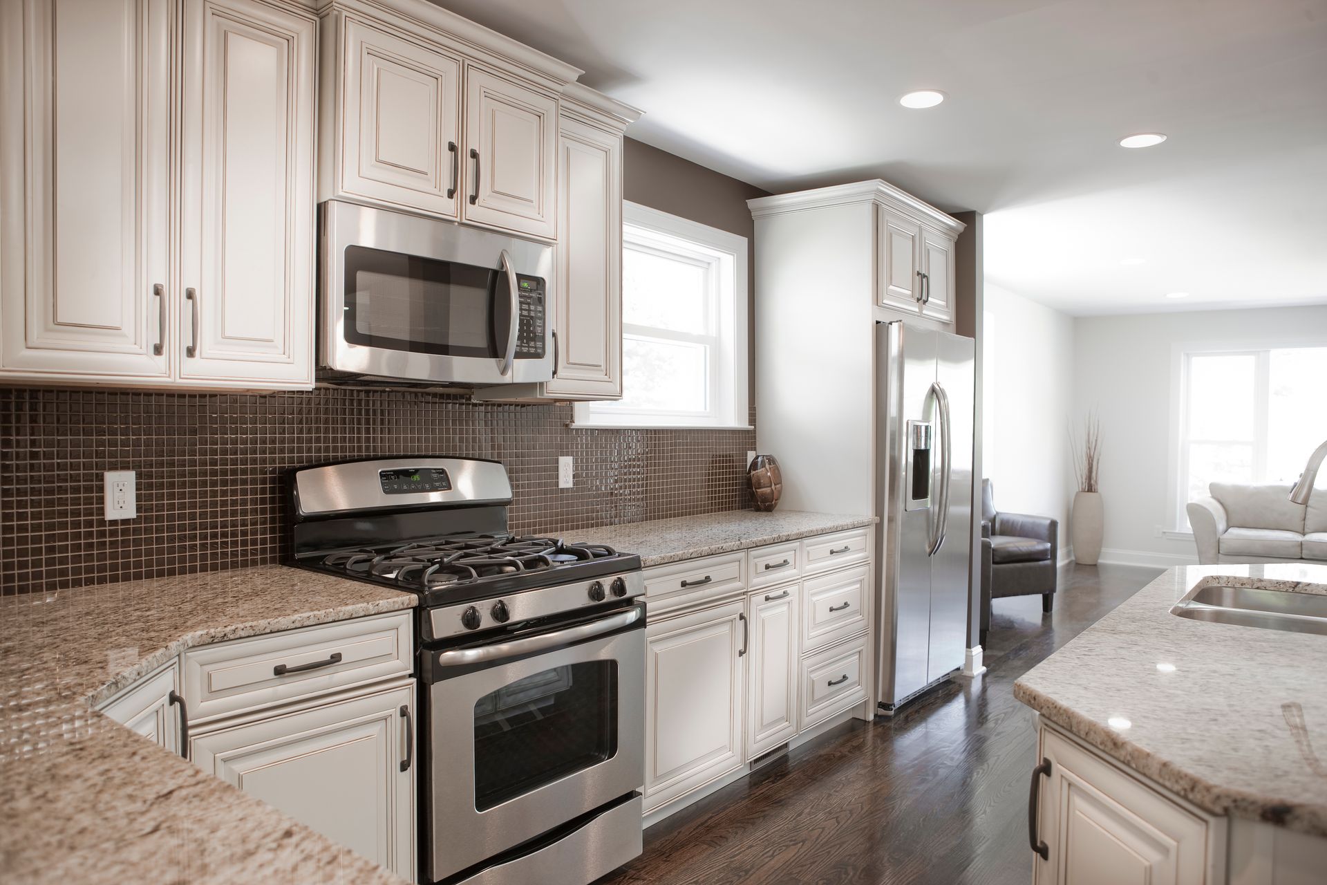 A kitchen with white cabinets , stainless steel appliances and granite counter tops.