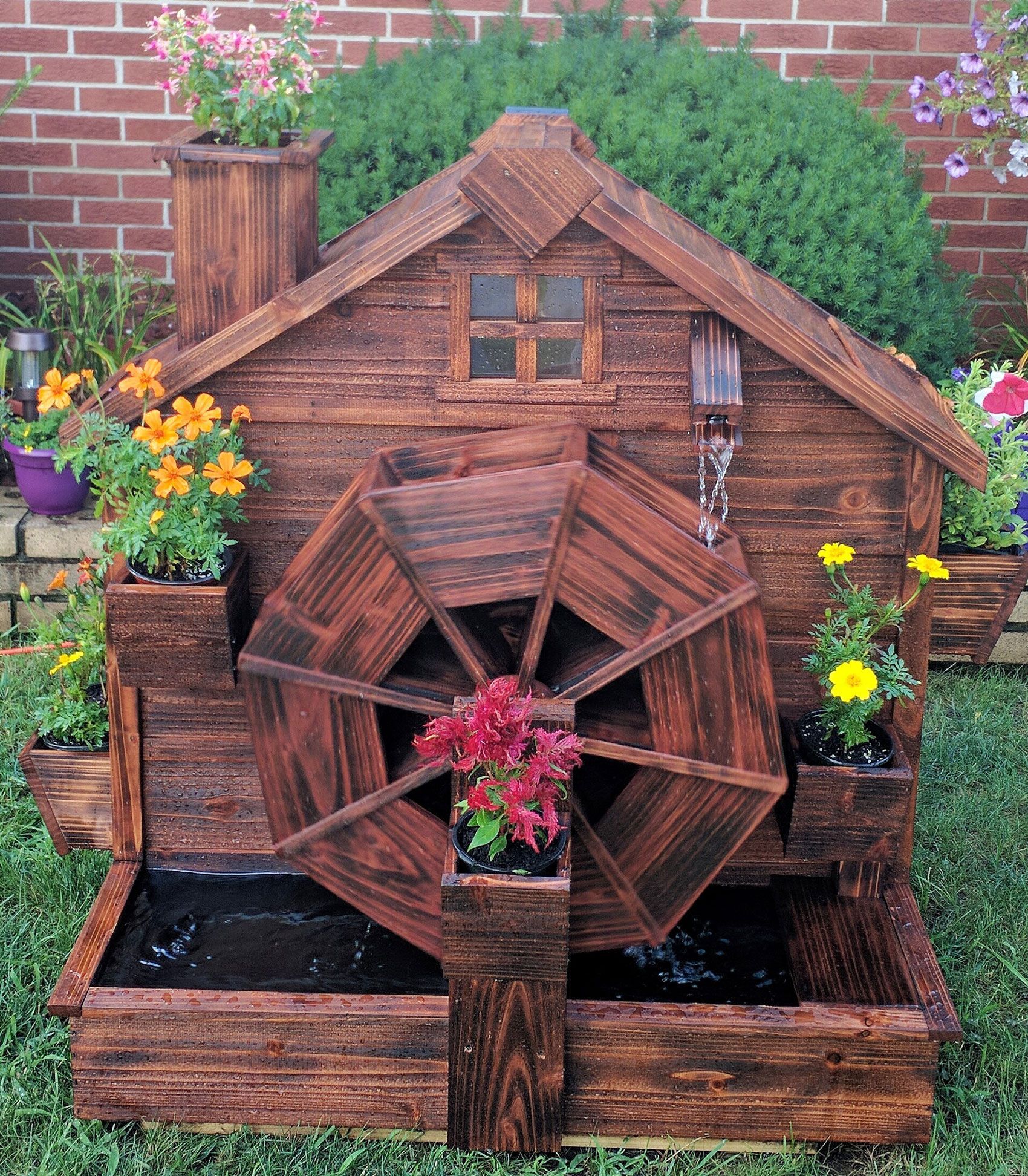 A wooden water wheel in the shape of a house