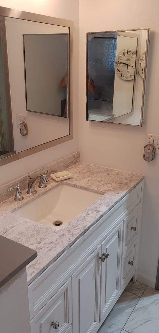 A bathroom with a sink , mirror and medicine cabinet.