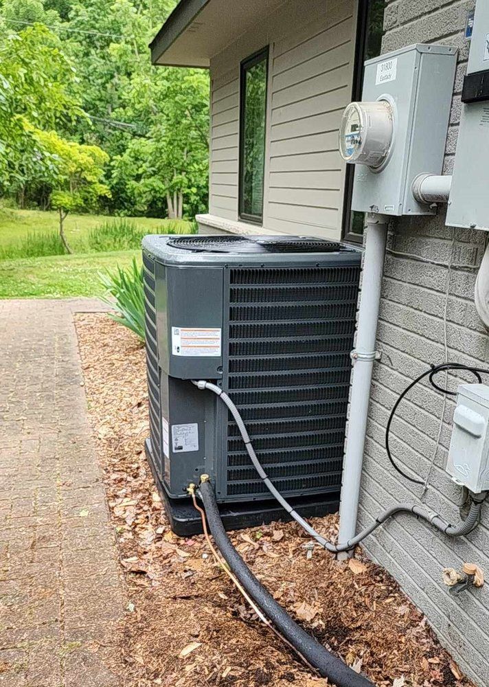 An air conditioner is sitting on the side of a house.