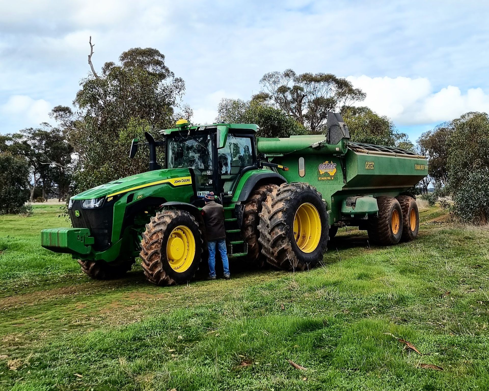 A combine harvester and a tractor are working in a wheat field.