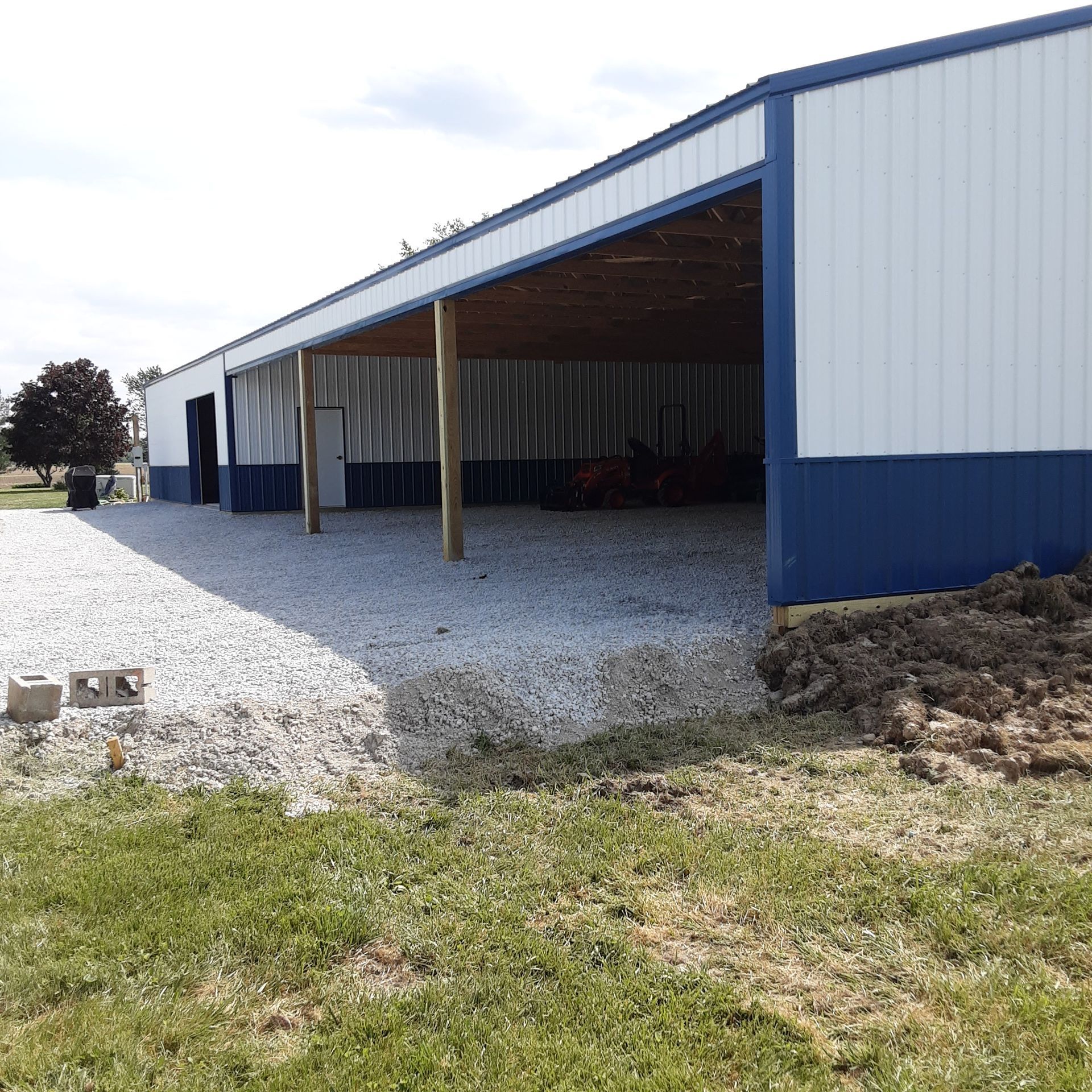 A blue and white building with a covered area in front of it