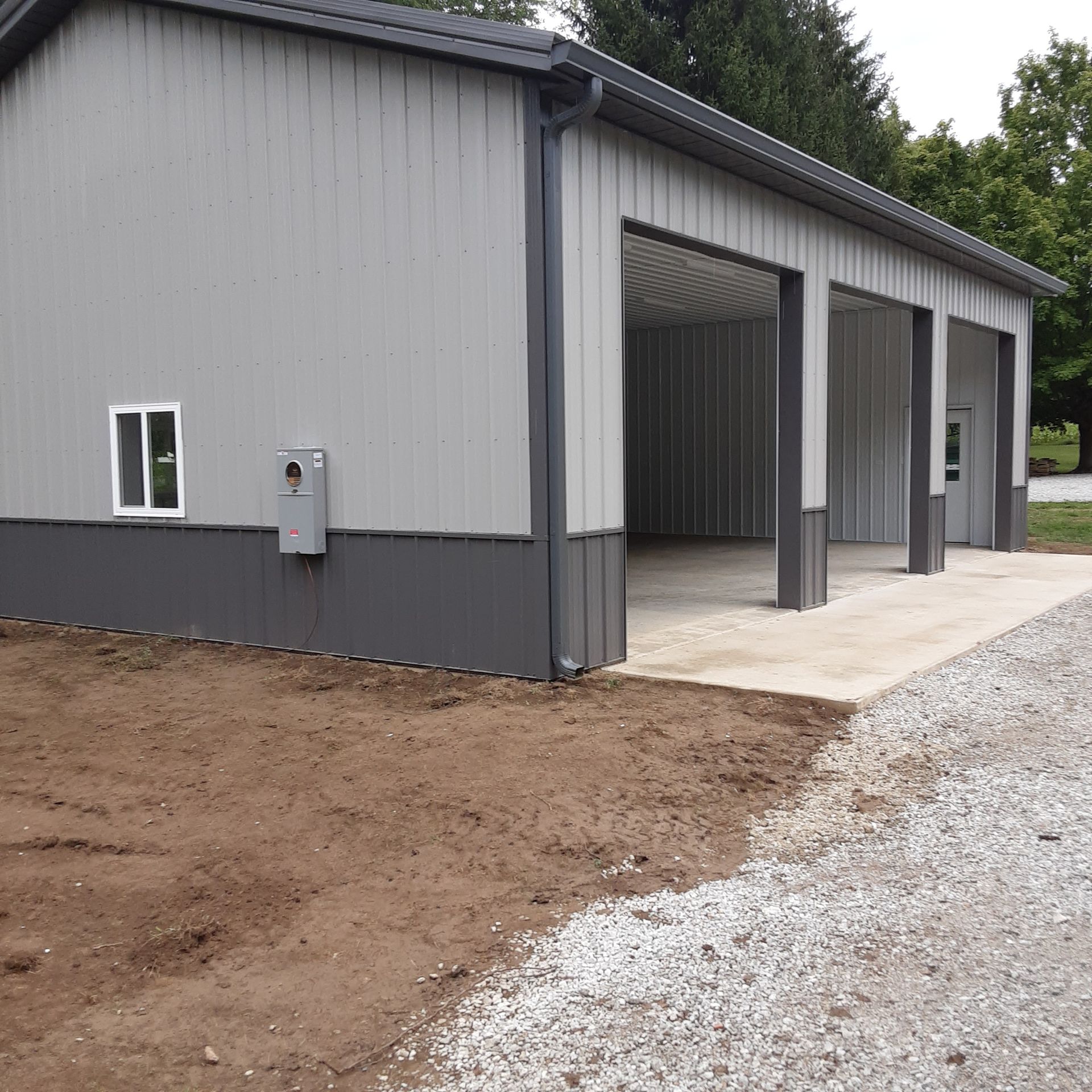 A gray building with a concrete driveway in front of it