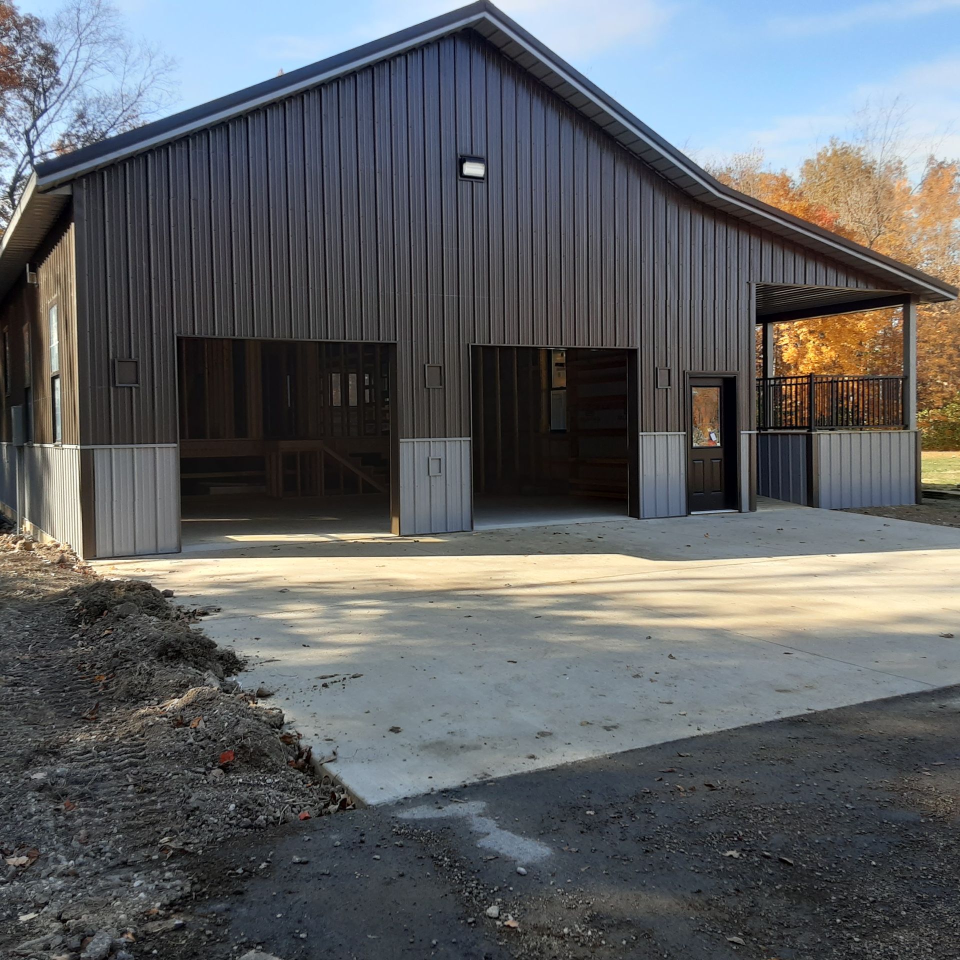 A large barn with a concrete driveway in front of it