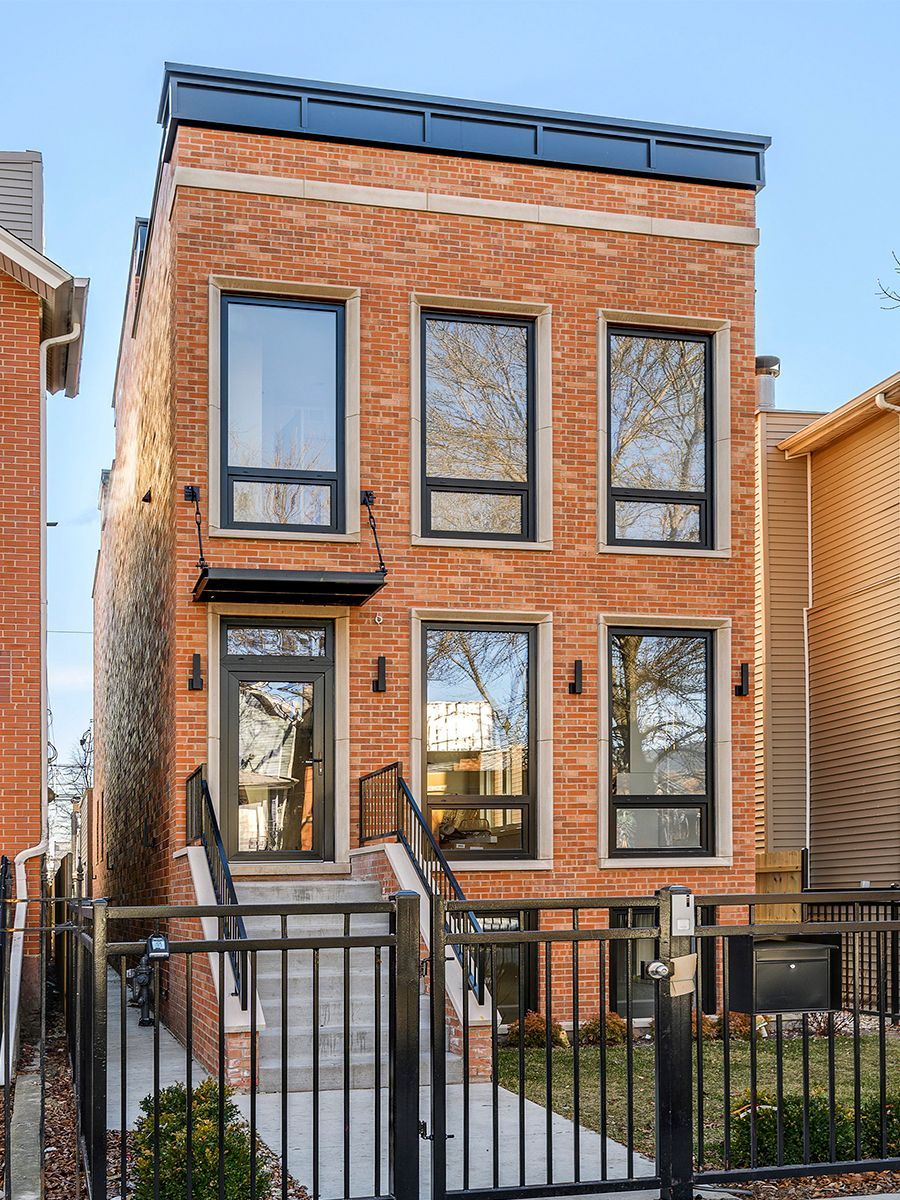 a brick building with a black fence around it