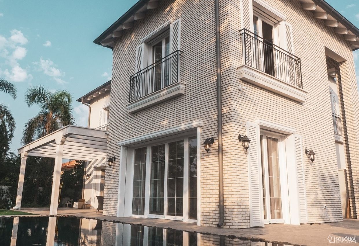 a brick house with white shutters on the windows