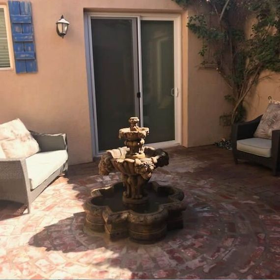 A patio with a couch and chairs and a fountain