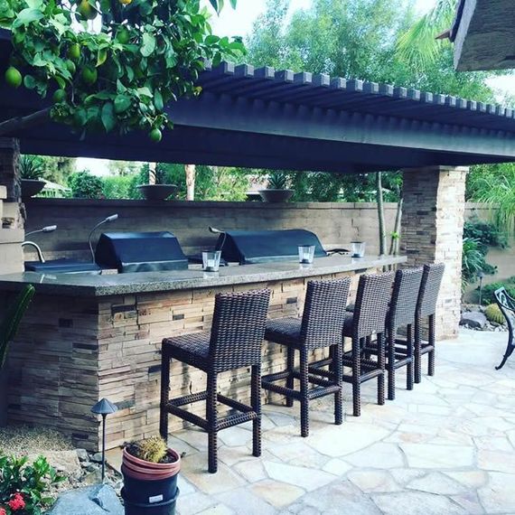 A patio area with a grill and wicker chairs