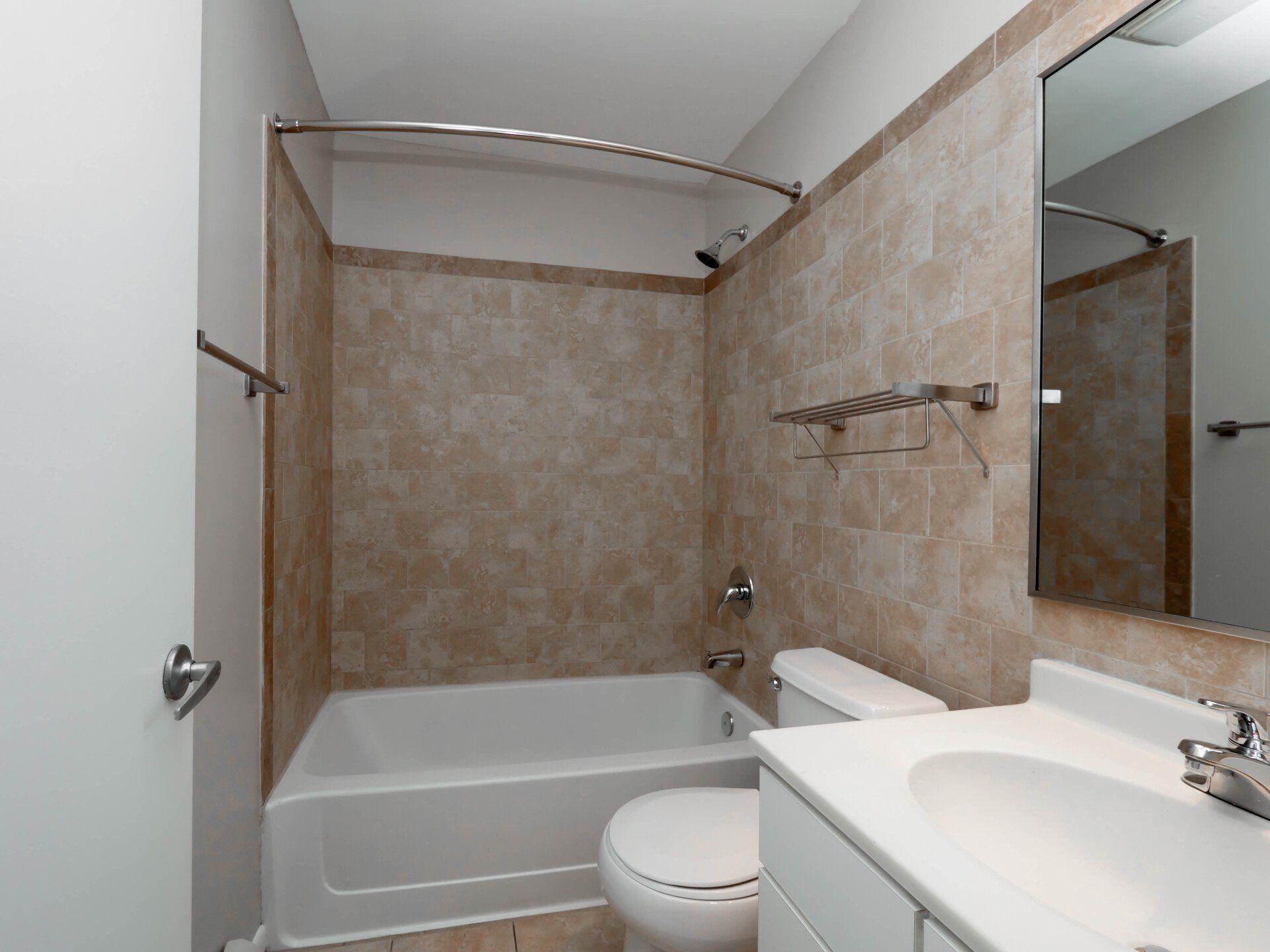 A bathroom with a tub, toilet, sink, and mirror at Reside on Morse.