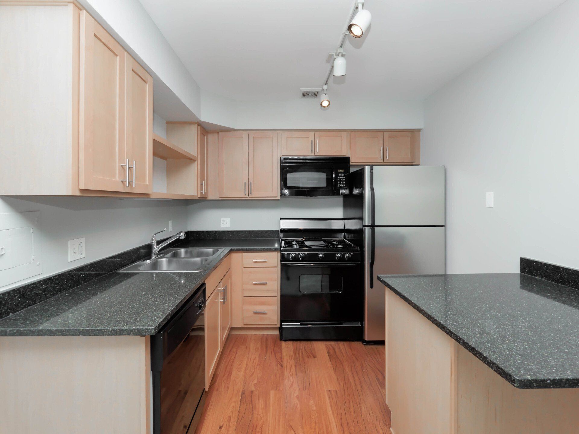 A kitchen with stainless steel appliances and granite countertops at Reside on Morse.