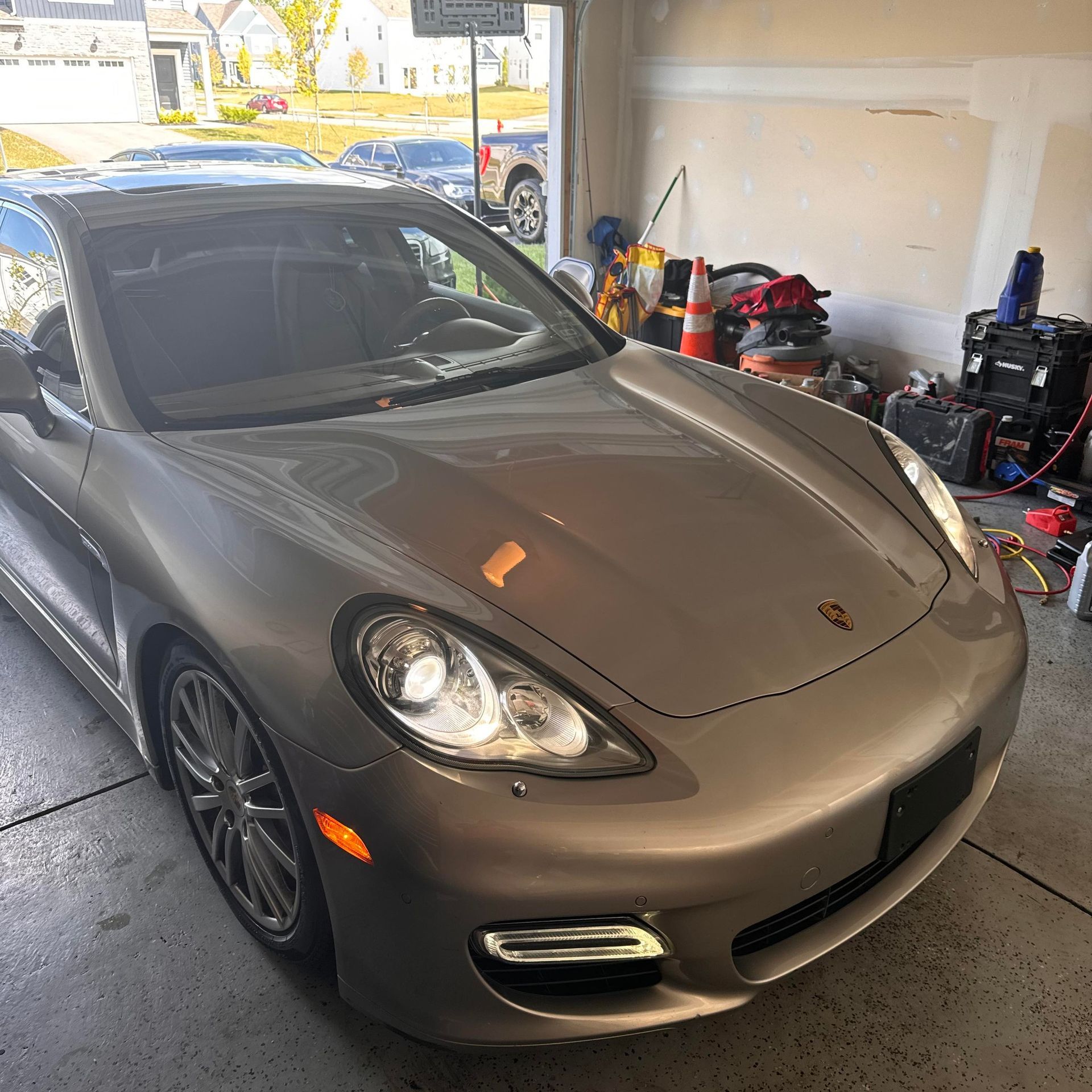 Silver Porsche Panamera parked inside a garage.