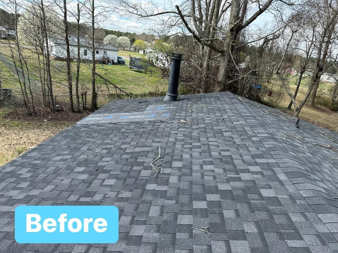 Rooftop with weathered gray shingles, a black chimney, and trees in the background, labeled 