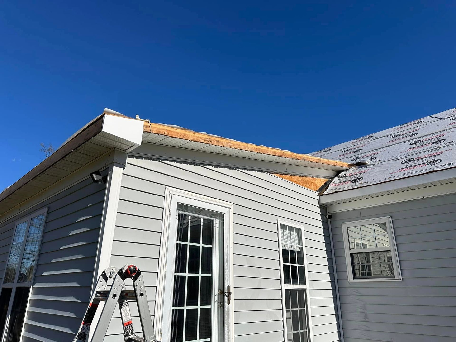 A ladder is sitting on the side of a house.