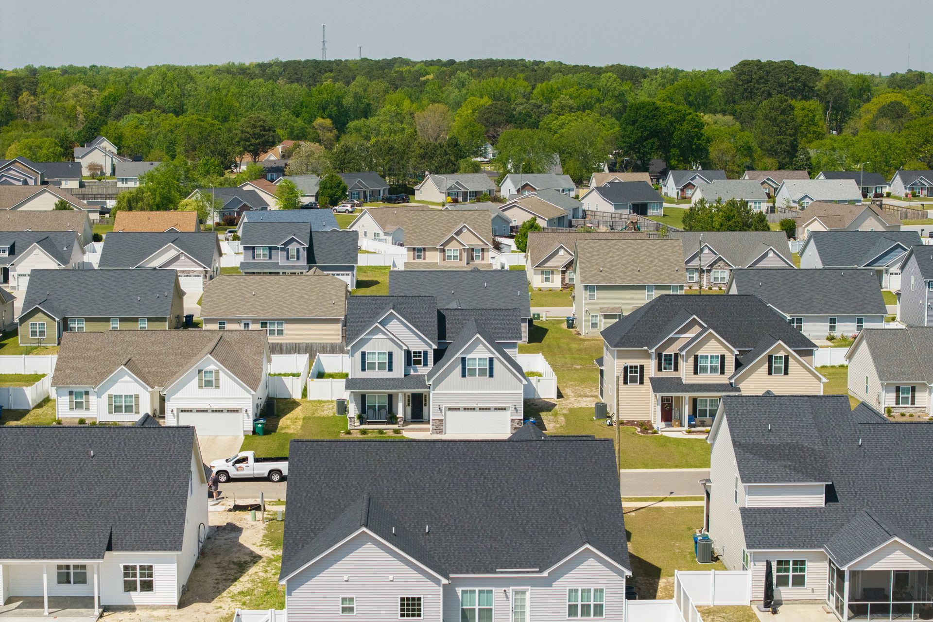A suburban neighborhood with homes in a row showcasing various rooftops.