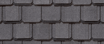 Close-up view of dark gray roofing shingles, overlapping in a repeating pattern.