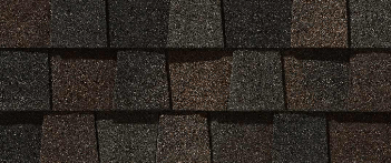 Close-up of asphalt roof shingles in a mix of brown and black tones.