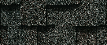Close-up of overlapping dark gray asphalt roof shingles.