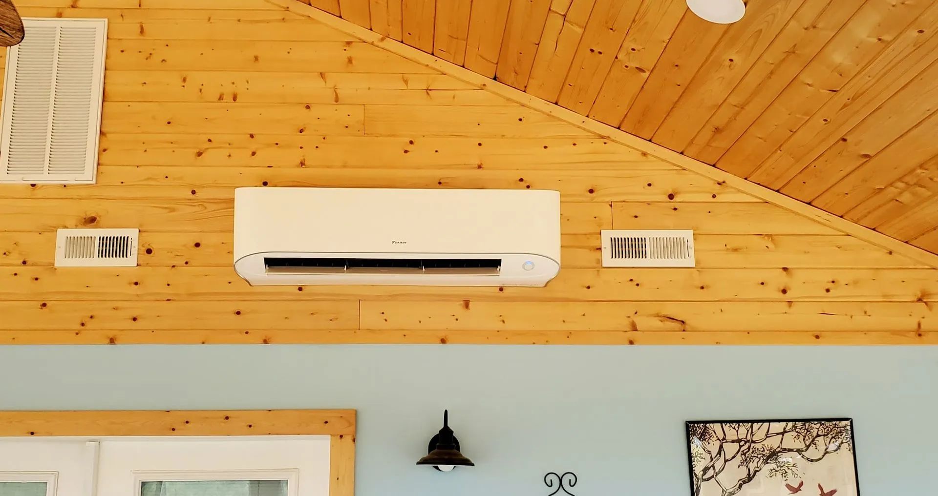 White air conditioner on a wood paneled wall. Blue wall below.