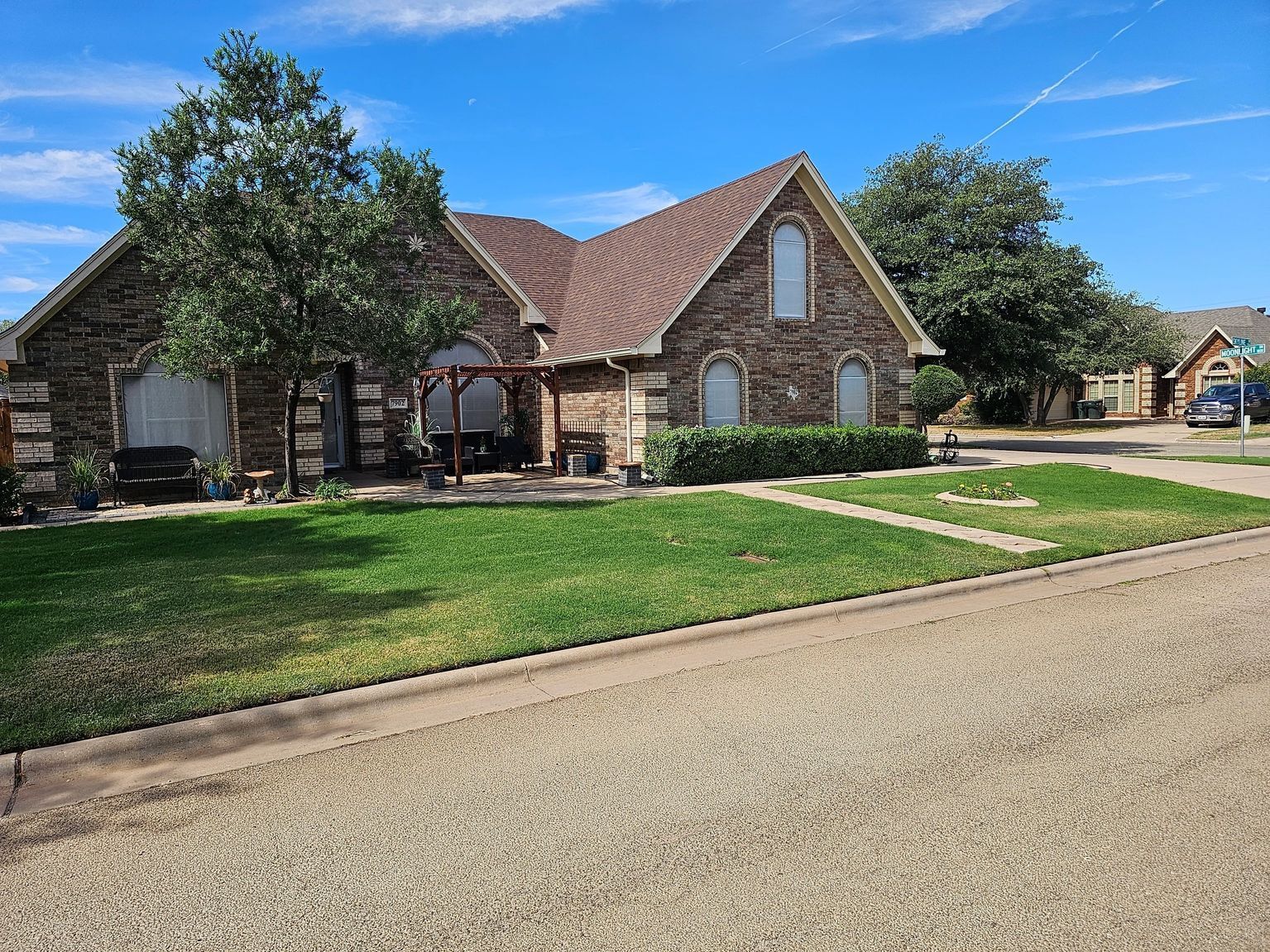 A large brick house with a lush green lawn in front of it