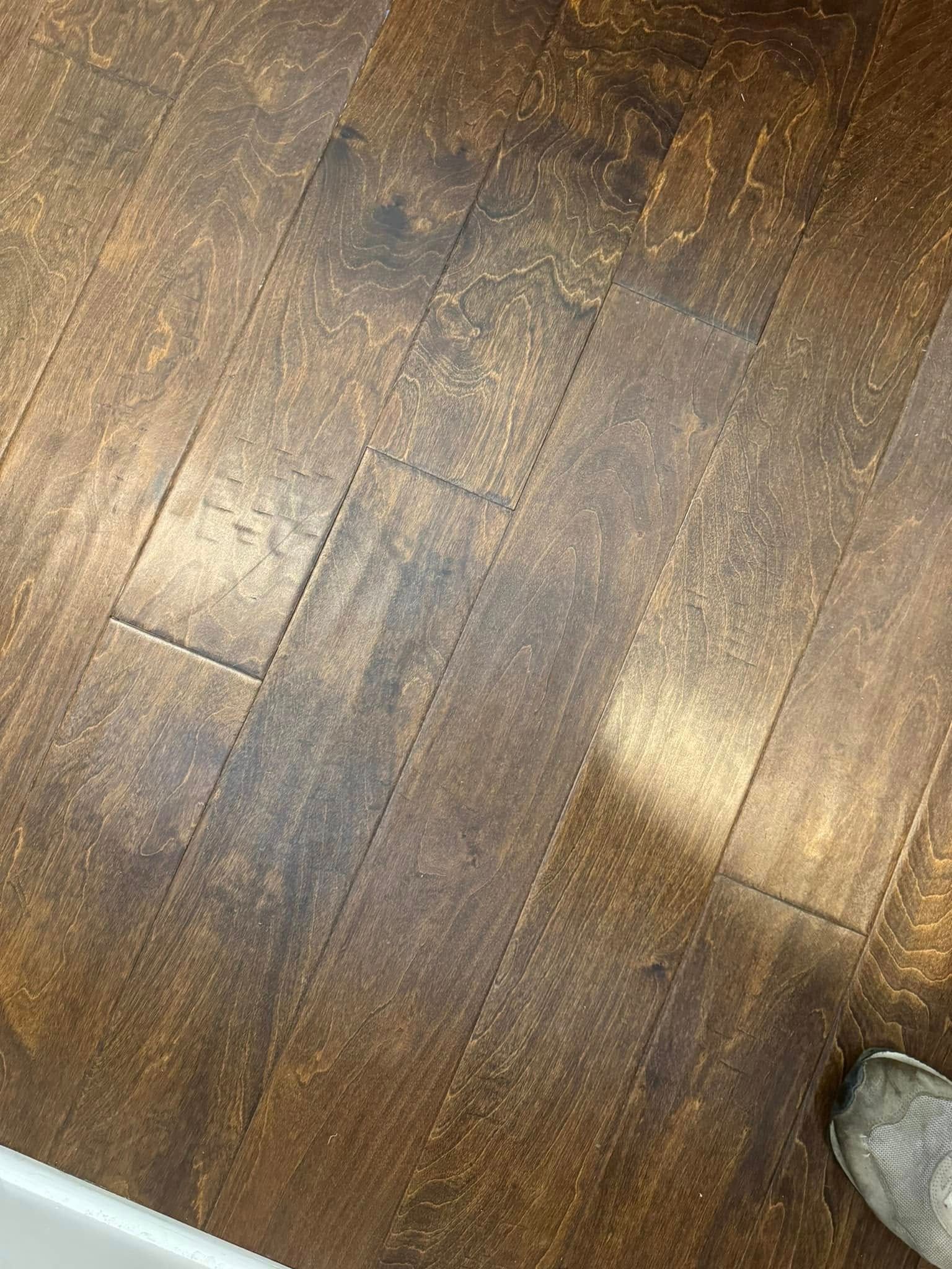 A close up of a wooden floor with a person standing on it.