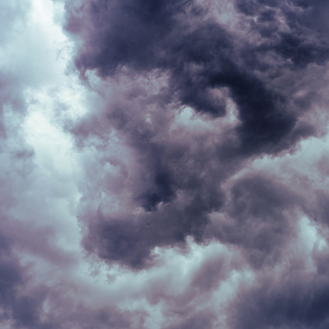 A close up of a cloudy sky with dark purple clouds