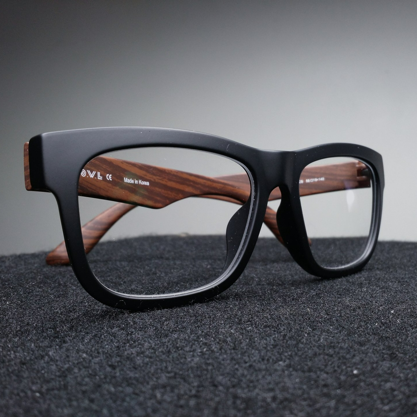 A pair of black glasses with wooden arms