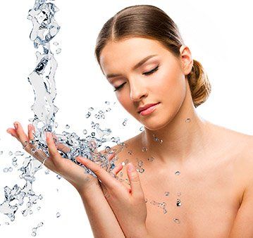 Beautiful woman splashing water on fresh skin.