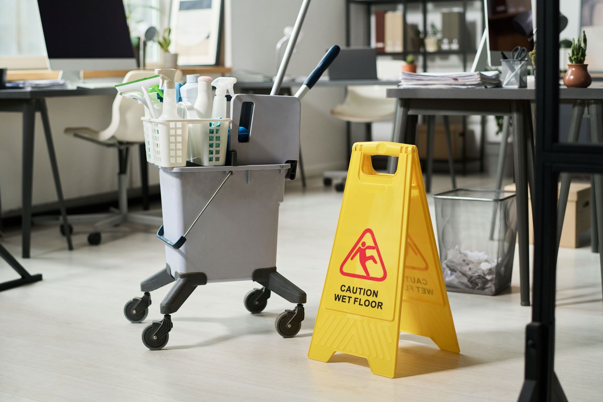 Cleaning cart and caution sign in an office setting.