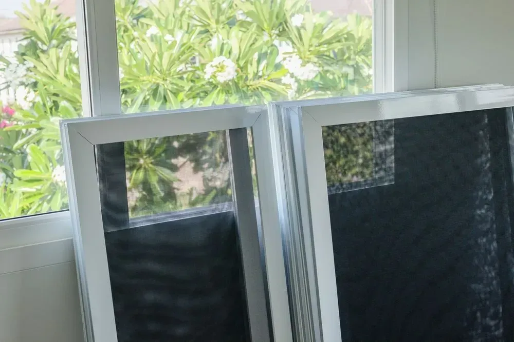 Two White-framed Window Screens Leaning Against a Window — Big Tom's Security Screens in Farleigh, QLD