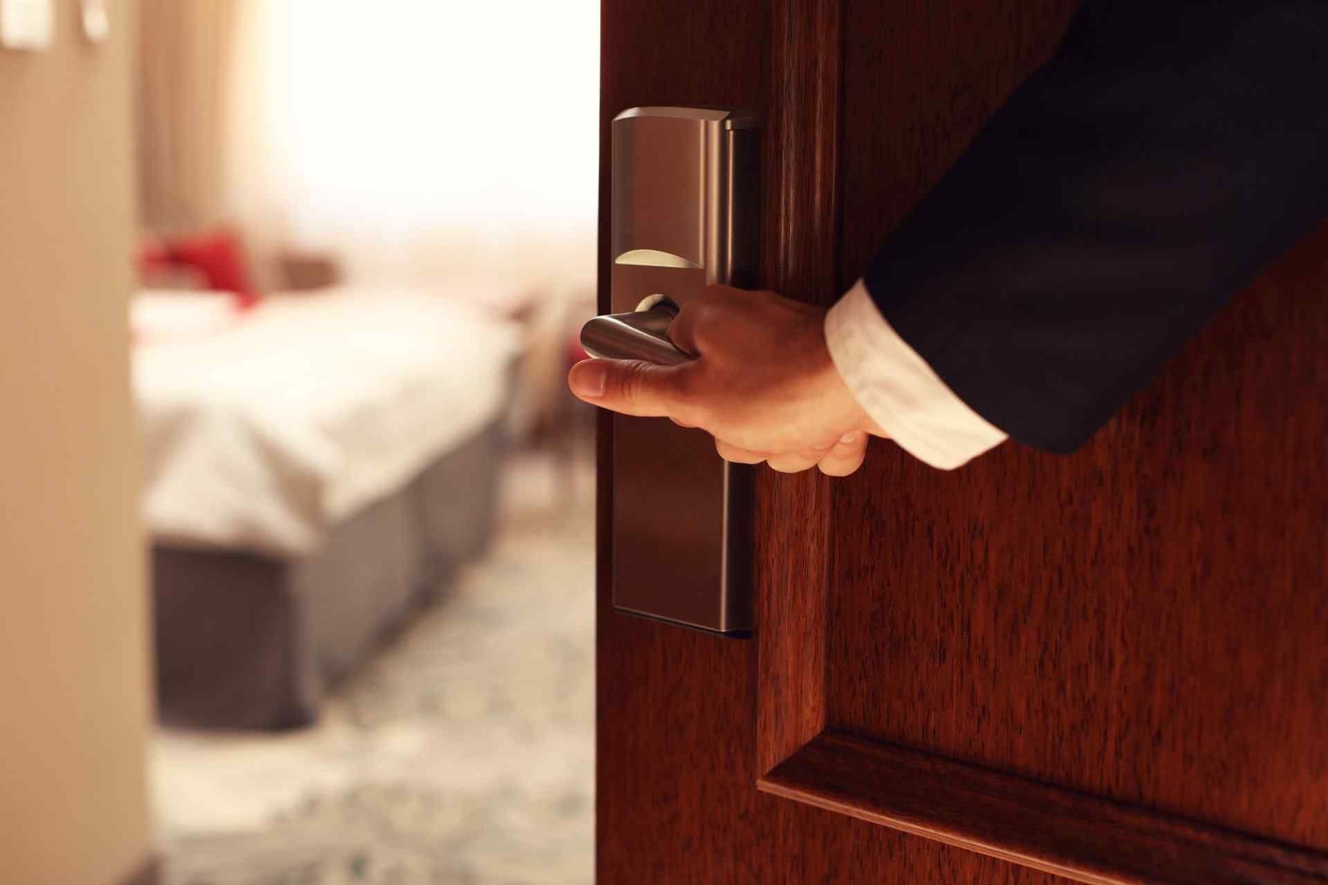 Hand in Suit Opening Hotel Room Door; Blurred Bed in Background — Big Tom's Security Screens in Farleigh, QLD