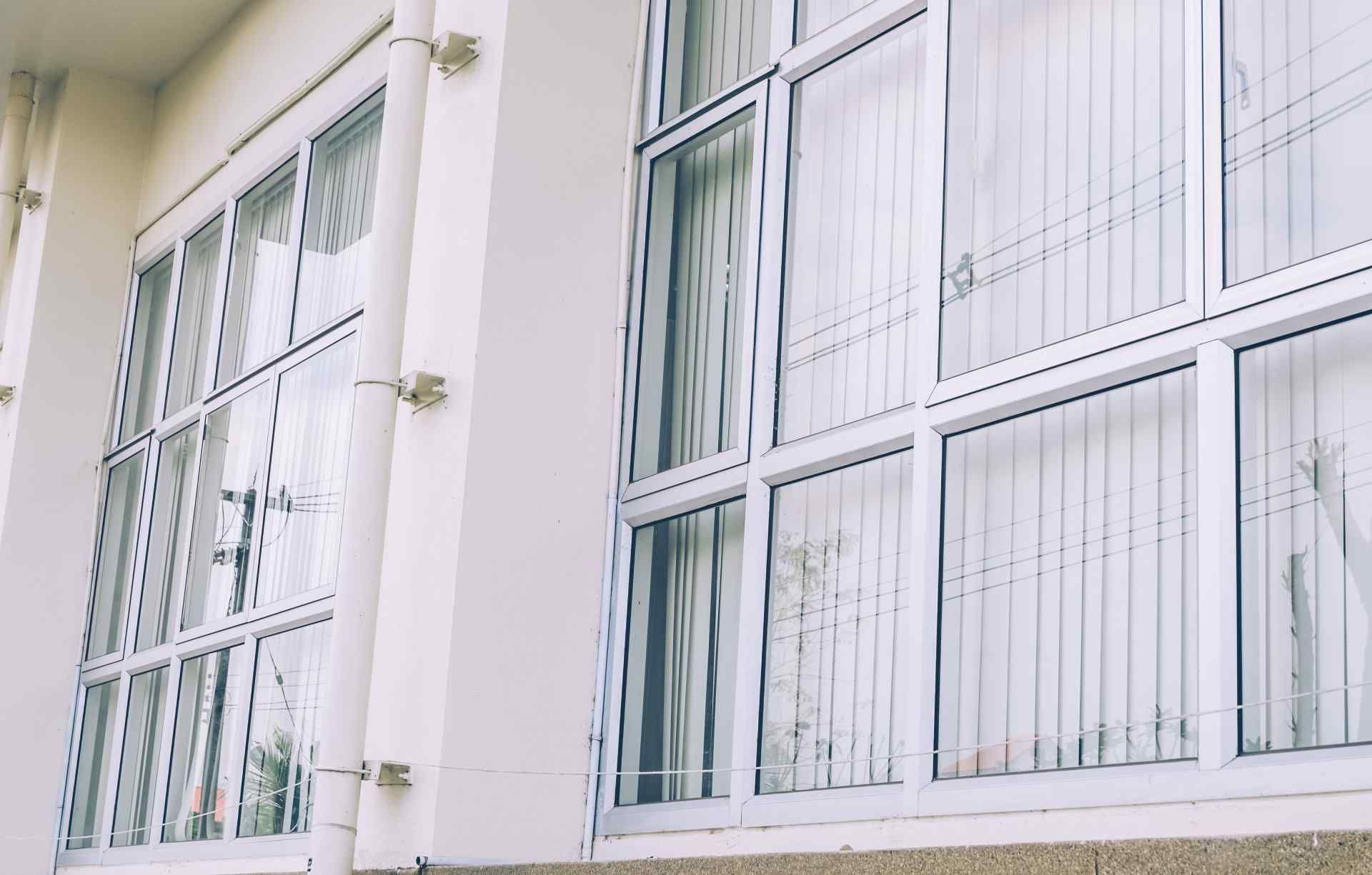 White Windows With White Frames on a White Building Wall — Big Tom's Security Screens in Farleigh, QLD