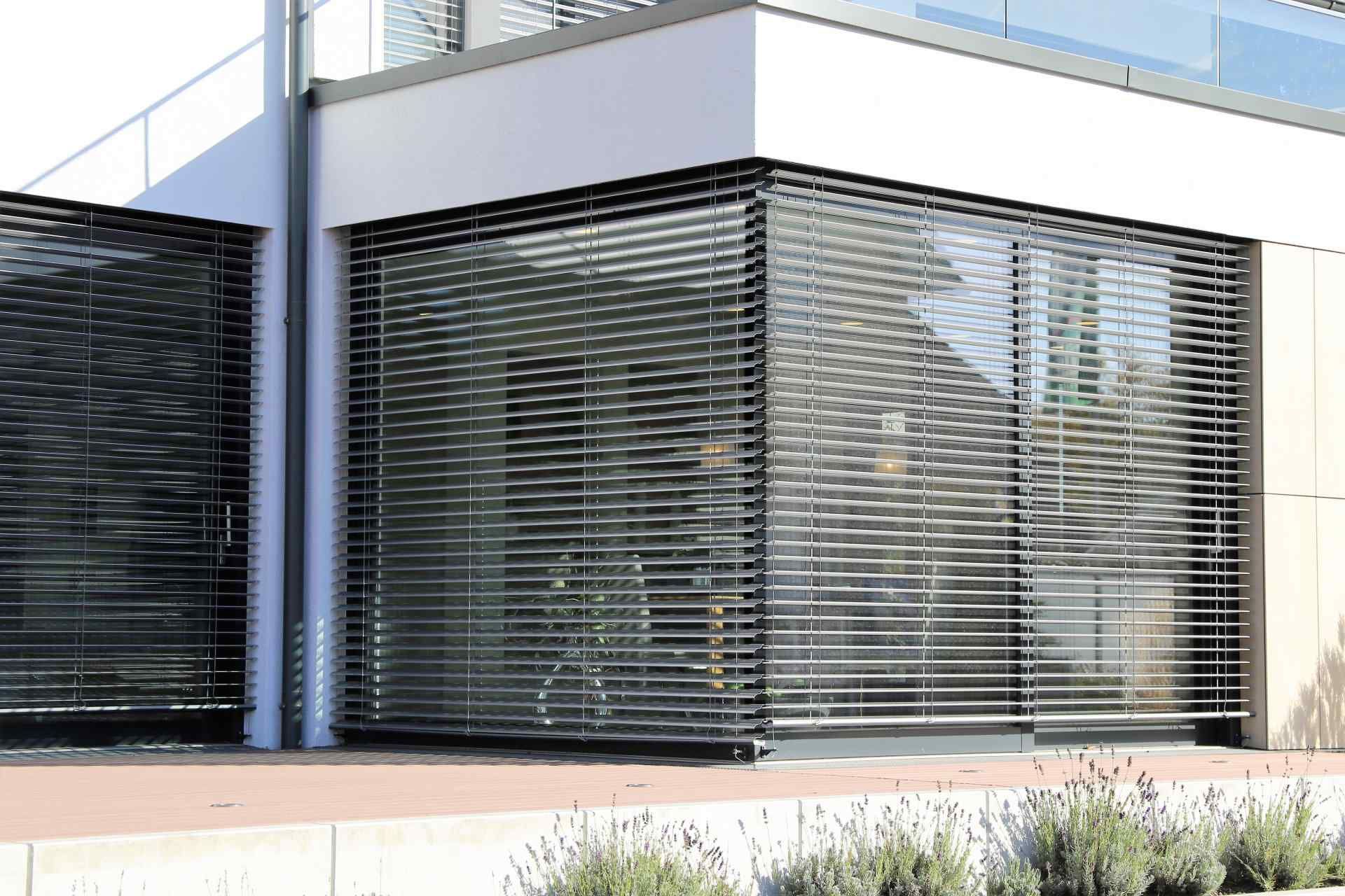 Modern Building With Horizontal Blinds Over Glass — Big Tom's Security Screens in Farleigh, QLD