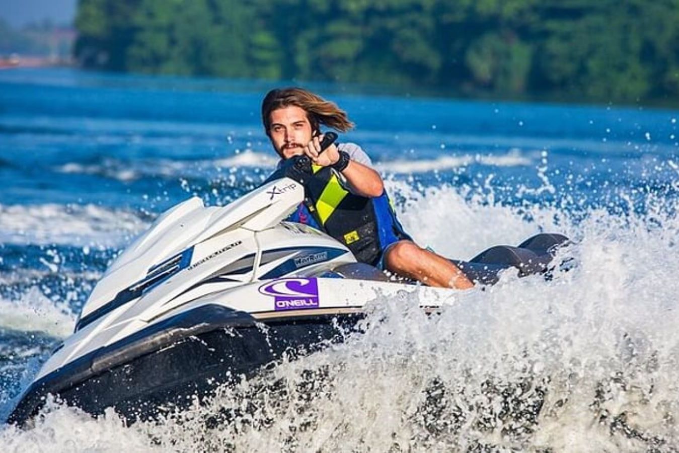 An action-shot of a man taking a sharp turn very quickly on a jetski.