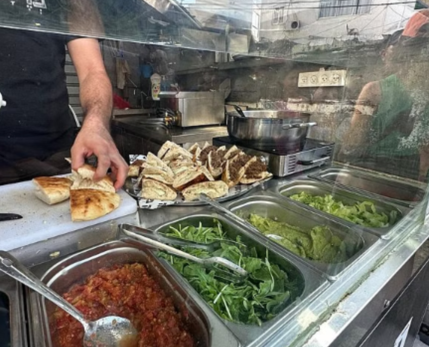 A man is preparing food in a restaurant kitchen