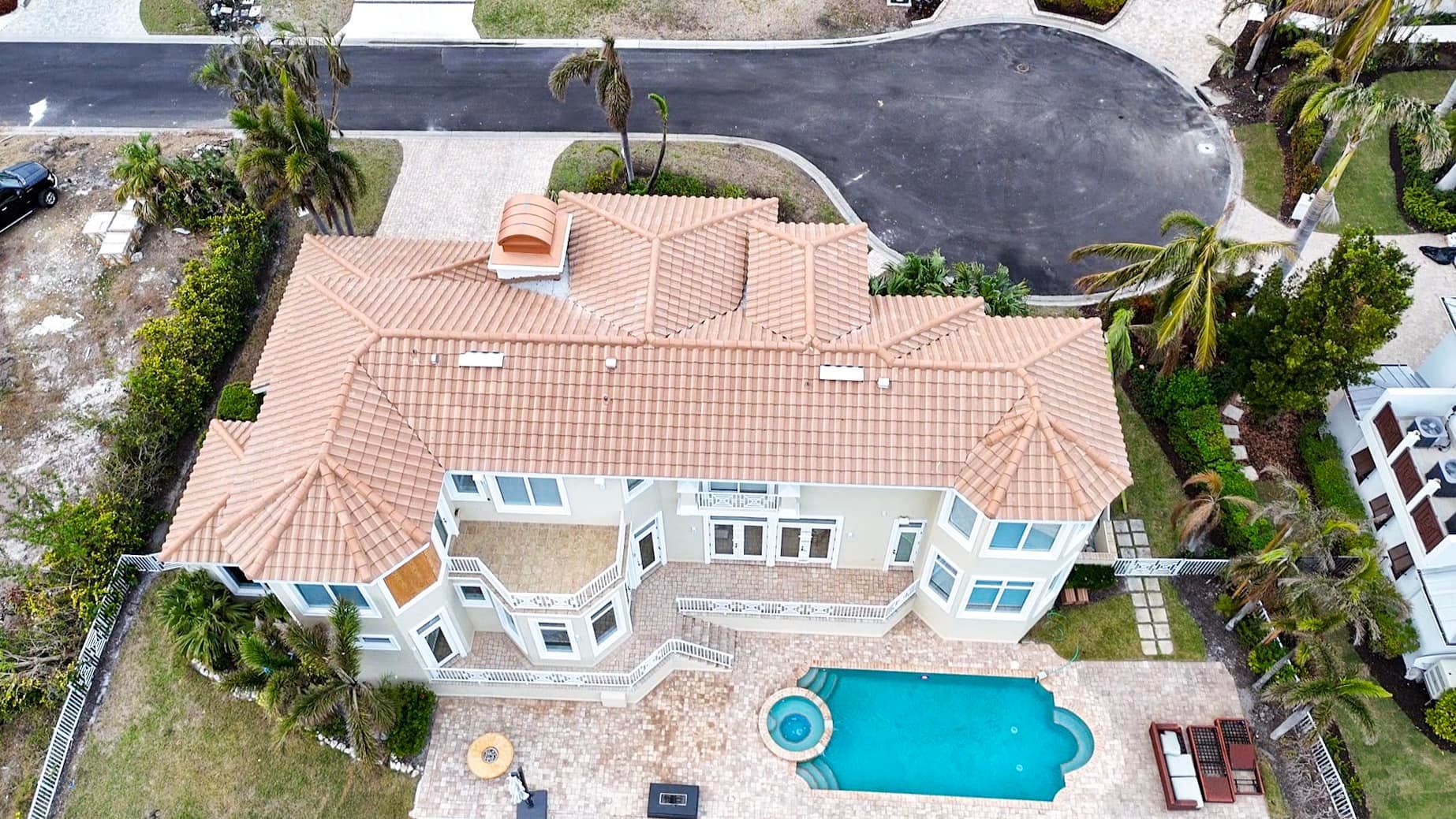 An aerial view of a large house with a pool in the backyard.