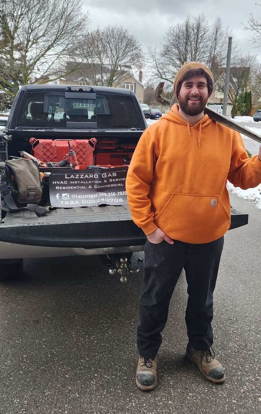 a man in an orange hoodie is standing in front of a truck .