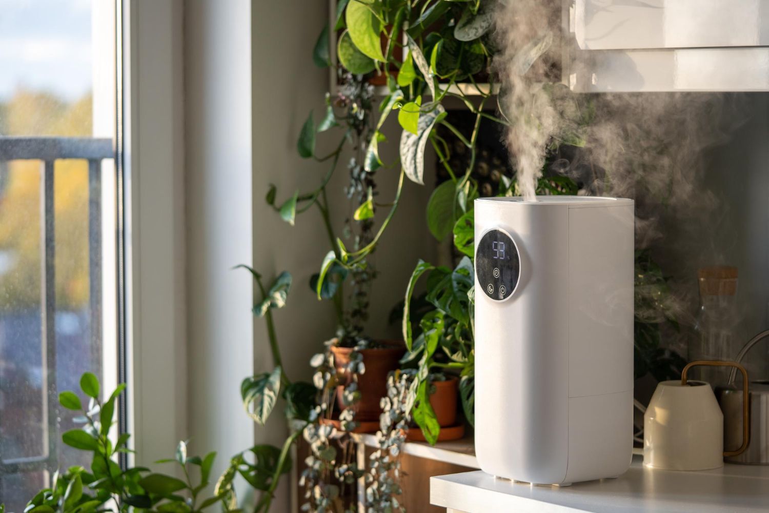 A white humidifier is sitting on a counter next to a window.
