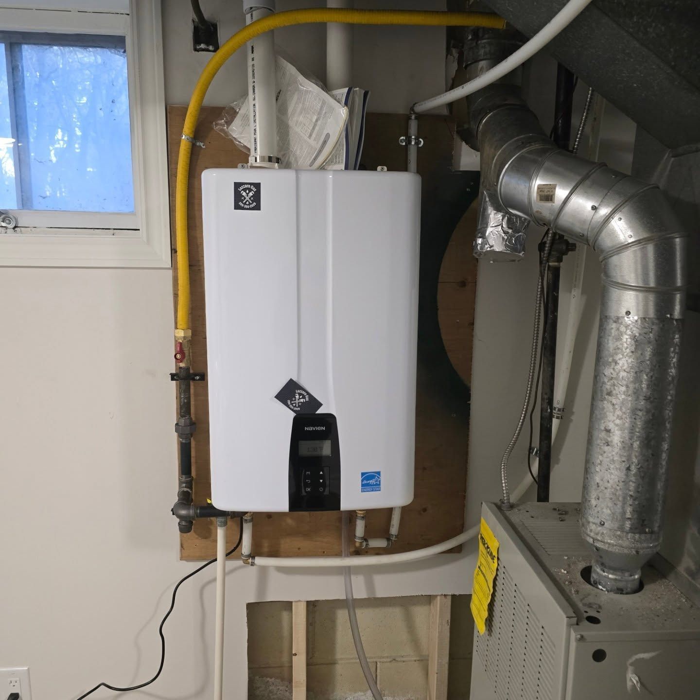Tankless water heater and furnace unit in a utility room.