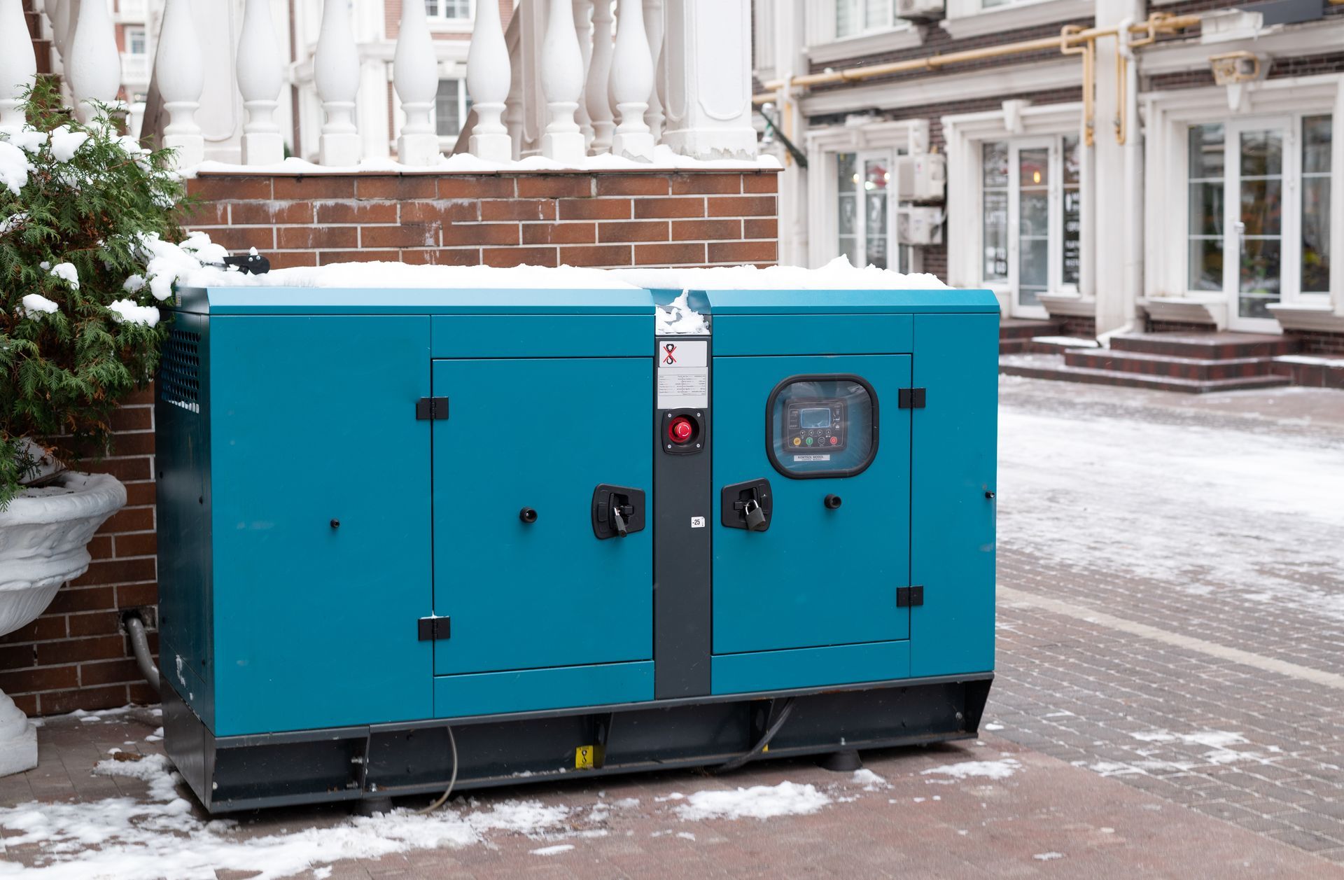 Blue generator outside a building with snow on the ground.