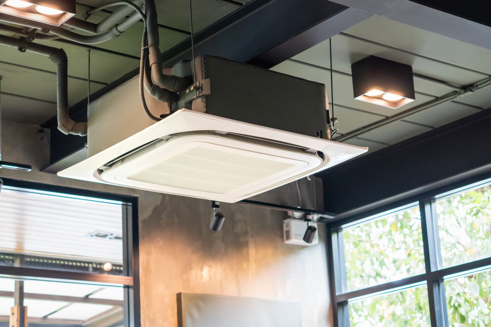 A ceiling fan is hanging from the ceiling of a room with a lot of windows.