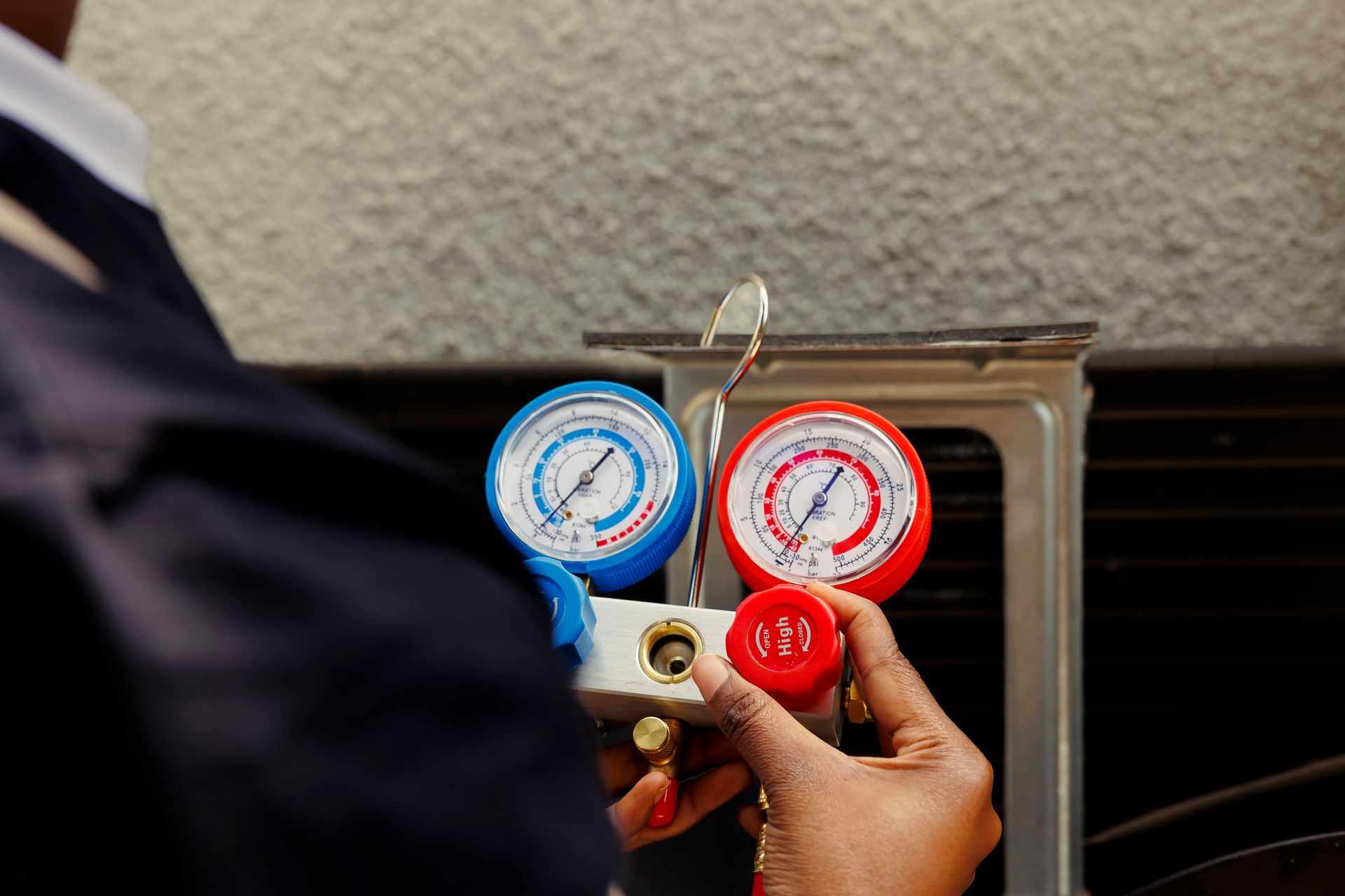 A person is holding a red and blue gauge in their hands.