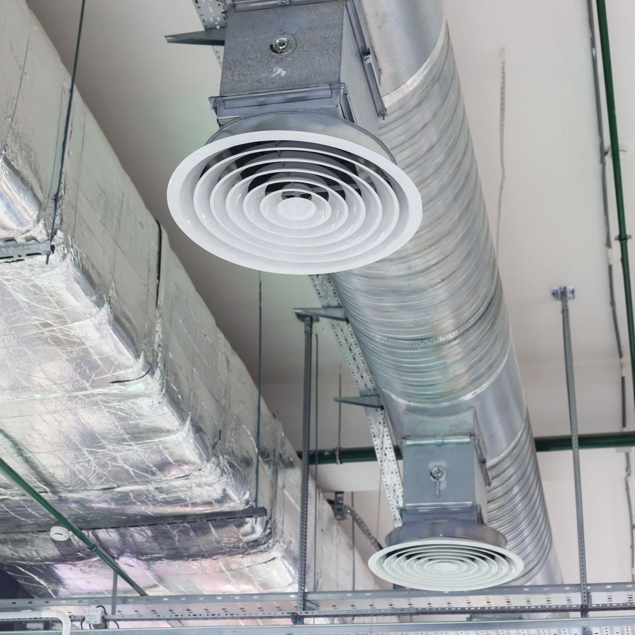 A ceiling with a lot of ducts hanging from it