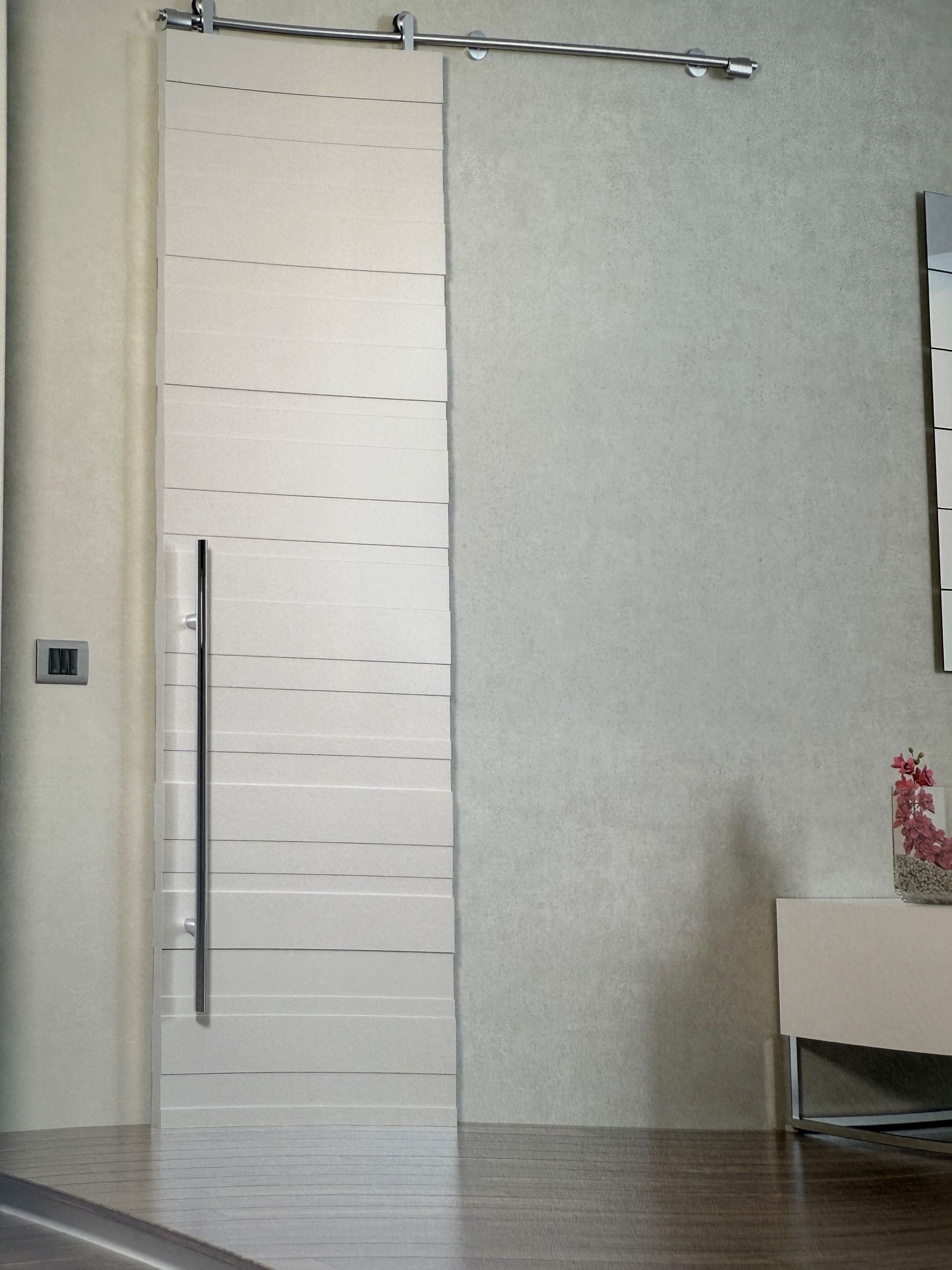 Una porta scorrevole in vetro con maniglia in acciaio inox