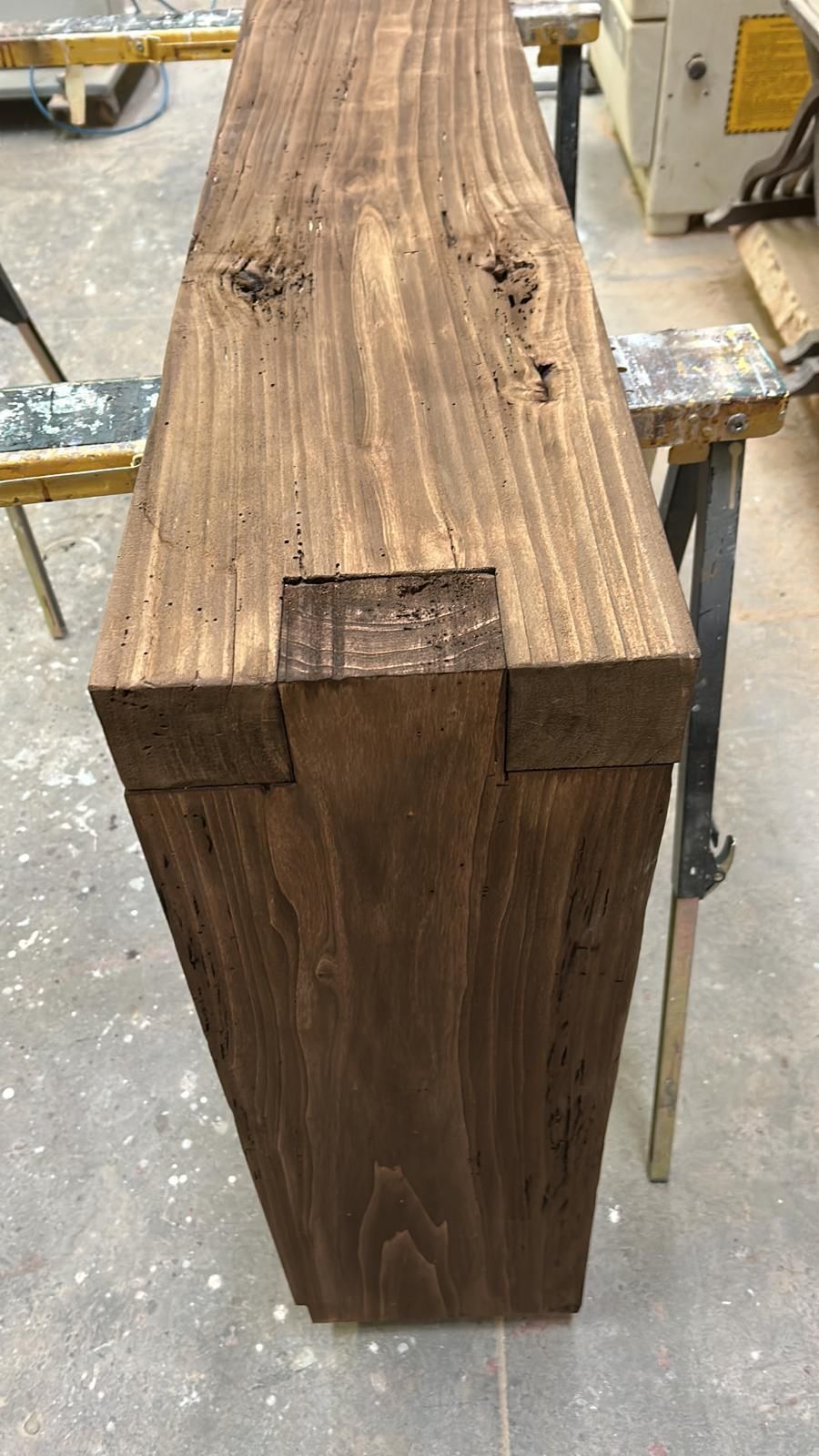 Un pezzo di legno è appoggiato su un tavolo in un'officina.