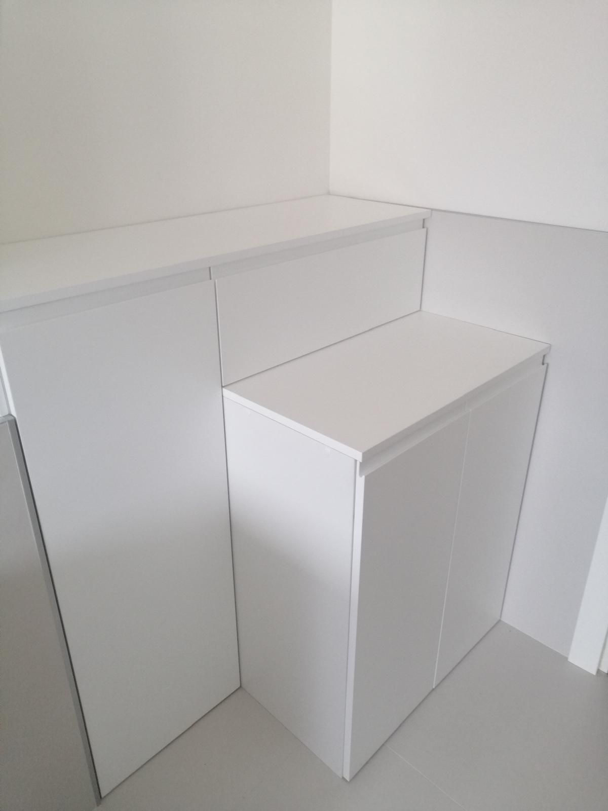 Un mobiletto bianco è appoggiato in un angolo della stanza.