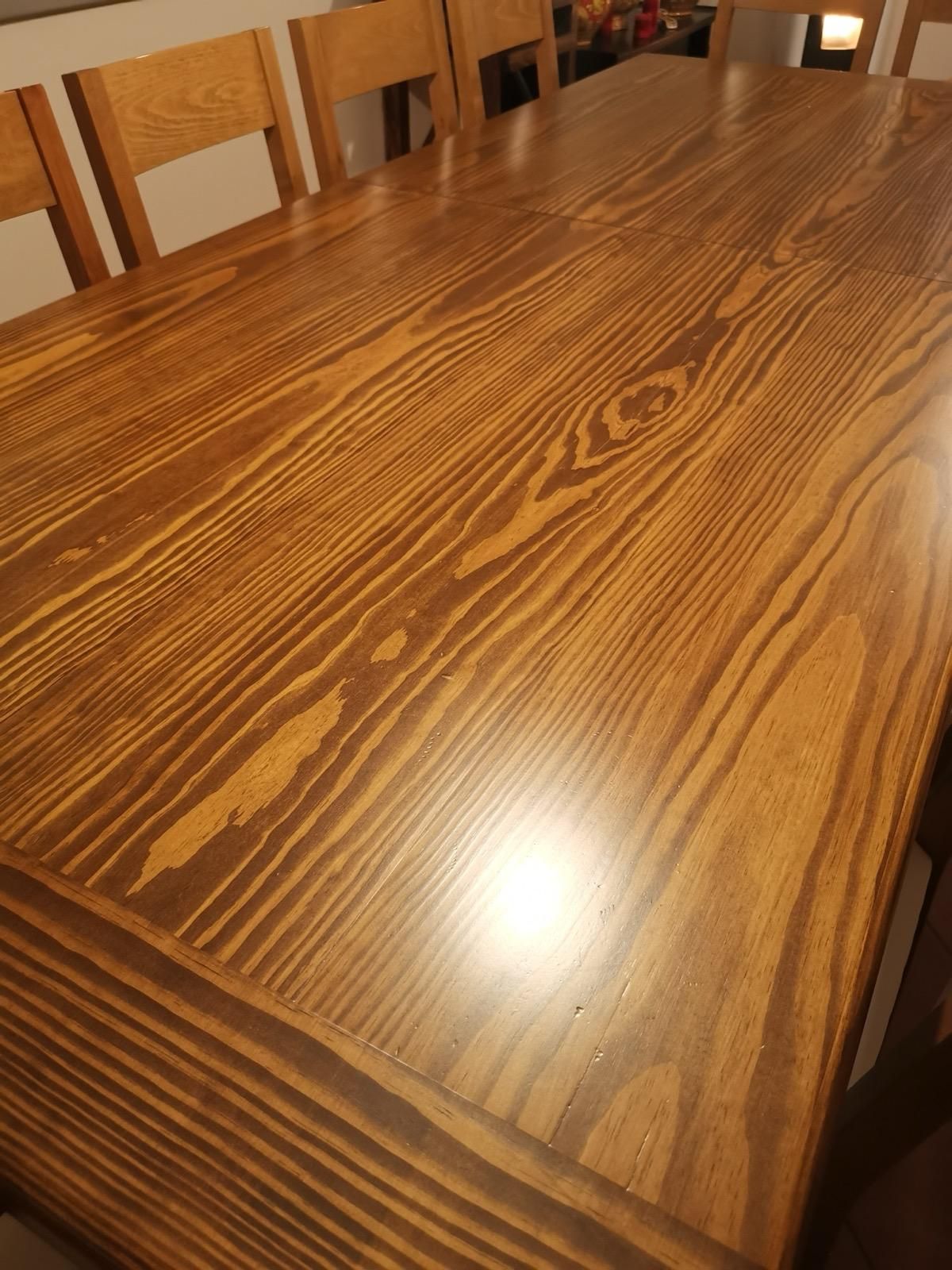 Un tavolo di legno con sedie attorno in una stanza