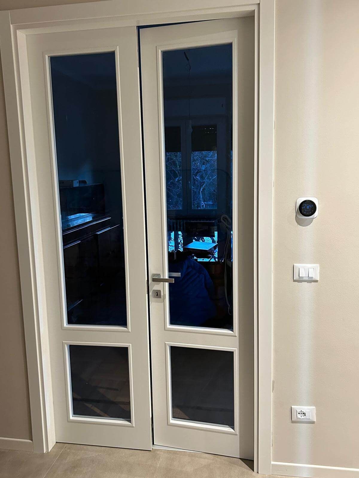 Una porta bianca con molto vetro in una stanza.